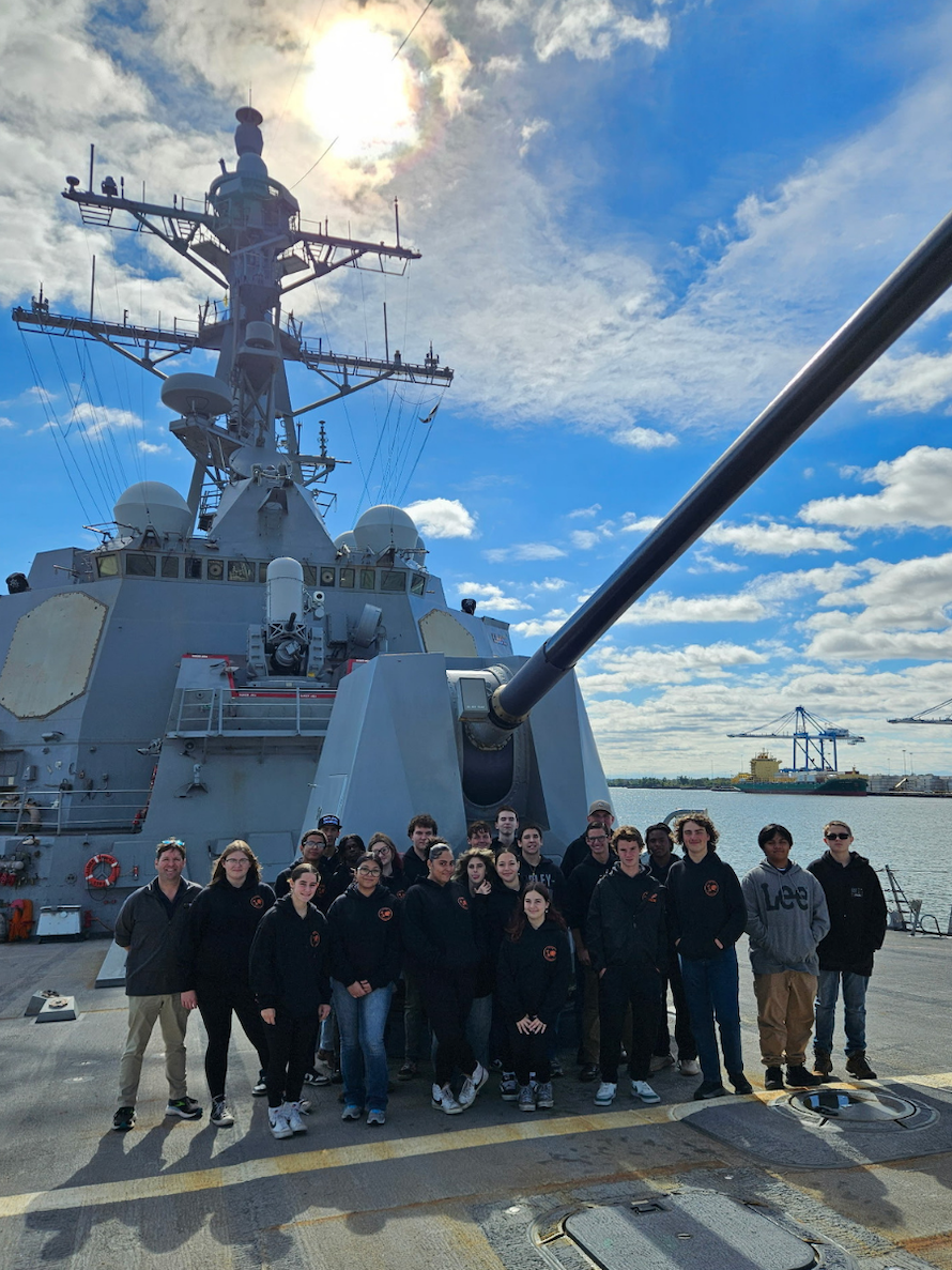 NNDCC students standing in front of a large ship